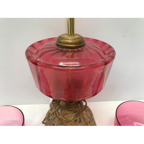 961 - Cranberry glass electrified oil lamp with cast iron base 39 cm H,  two cranberry bowls 11.5 cm w and... 