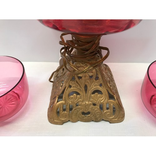 961 - Cranberry glass electrified oil lamp with cast iron base 39 cm H,  two cranberry bowls 11.5 cm w and... 