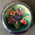 A Moorcroft circular dish, 11.5cms h, blue ground with floral decoration.