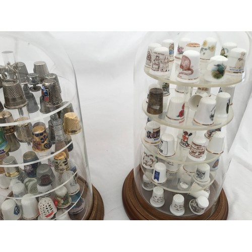 70 - A large collection of thimbles, porcelain white and gilt, metal and enamelled in three dome glass ca... 