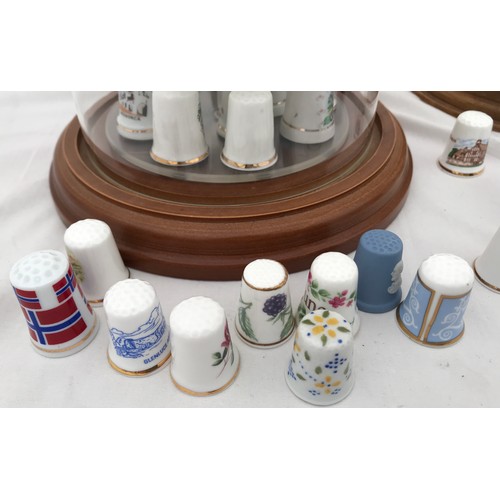 70 - A large collection of thimbles, porcelain white and gilt, metal and enamelled in three dome glass ca... 