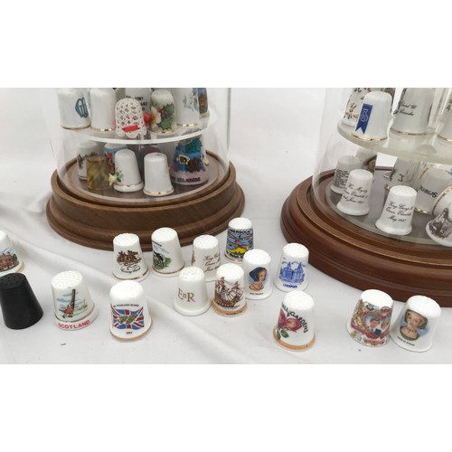 70 - A large collection of thimbles, porcelain white and gilt, metal and enamelled in three dome glass ca... 