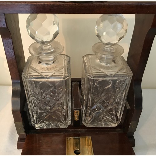 105 - A mahogany cased two bottle tantalus with Royal Doulton crystal glass decanters with key. 29cms h x ... 