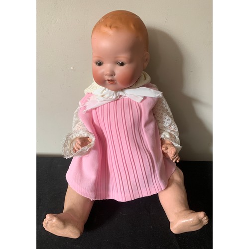 701 - A bisque headed baby doll with closing brown eyes. Marked to back of head A.M. Germany 351/8.k. Dres... 