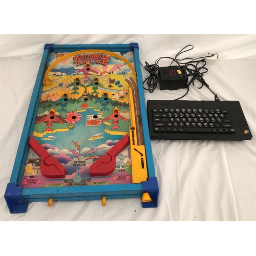 707 - A Sinclair ZX Spectrum+ keyboard and power adaptor with a tin and plastic pinball game.