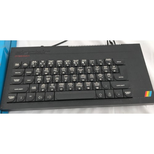 707 - A Sinclair ZX Spectrum+ keyboard and power adaptor with a tin and plastic pinball game.