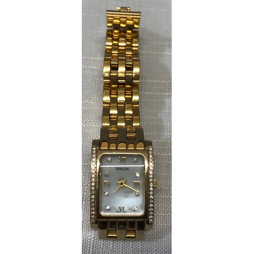 712 - An Odeon ladies wristwatch with a gold plated case and strap. Case set with clear cut stones. Number... 