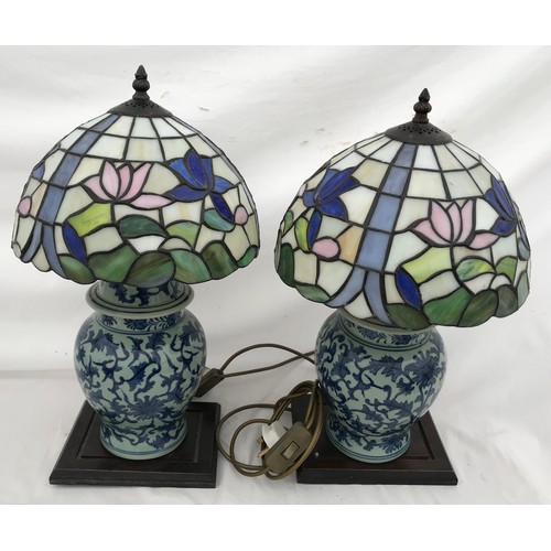 749 - A pair of blue and white Chinese pottery table lamps with Tiffany style leaded floral patterned glas... 