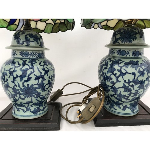 749 - A pair of blue and white Chinese pottery table lamps with Tiffany style leaded floral patterned glas... 