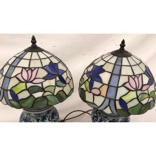 749 - A pair of blue and white Chinese pottery table lamps with Tiffany style leaded floral patterned glas... 