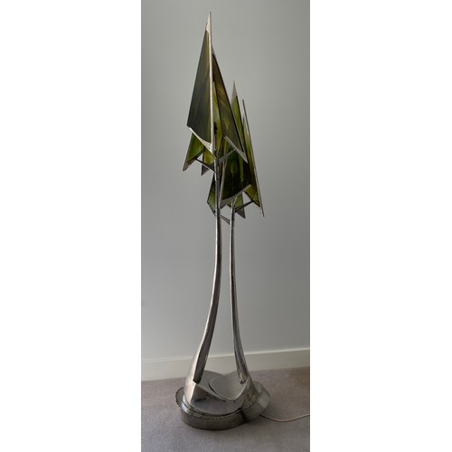 756 - A steel sculpture standard lamp with green glass conical shades and twin stem. 207 h, base width app... 