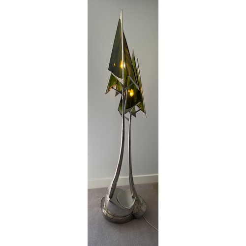 756 - A steel sculpture standard lamp with green glass conical shades and twin stem. 207 h, base width app... 