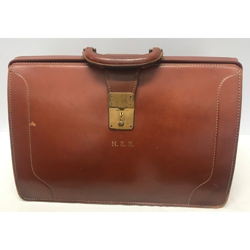 910 - A collection of 3 leather brief cases to include a tan leather Doctors bag opening brief case stampe... 