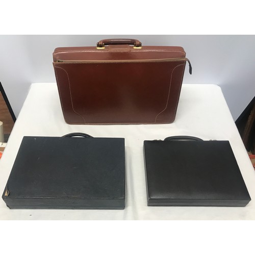 910 - A collection of 3 leather brief cases to include a tan leather Doctors bag opening brief case stampe... 