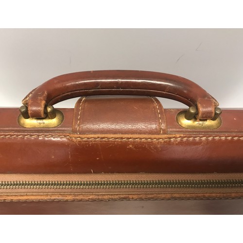 910 - A collection of 3 leather brief cases to include a tan leather Doctors bag opening brief case stampe... 