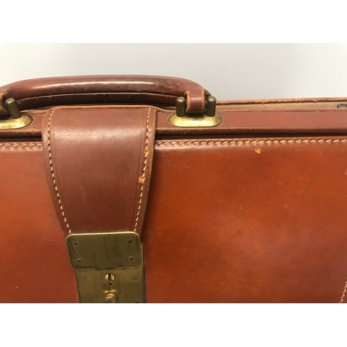 910 - A collection of 3 leather brief cases to include a tan leather Doctors bag opening brief case stampe... 