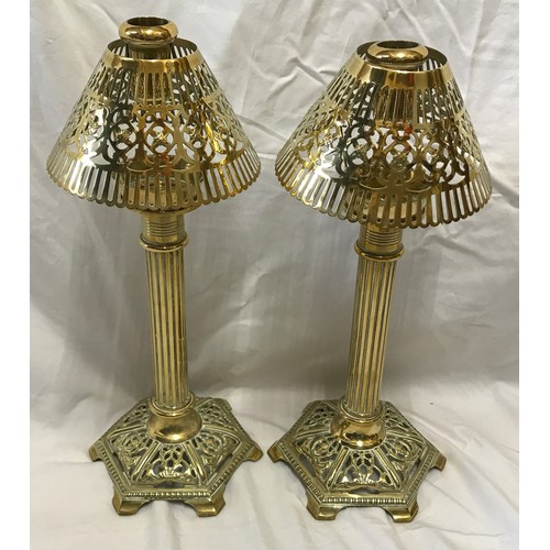 921 - A pair of brass candlesticks with Corinthian columns and decorative pierced shades and base. Approx.... 