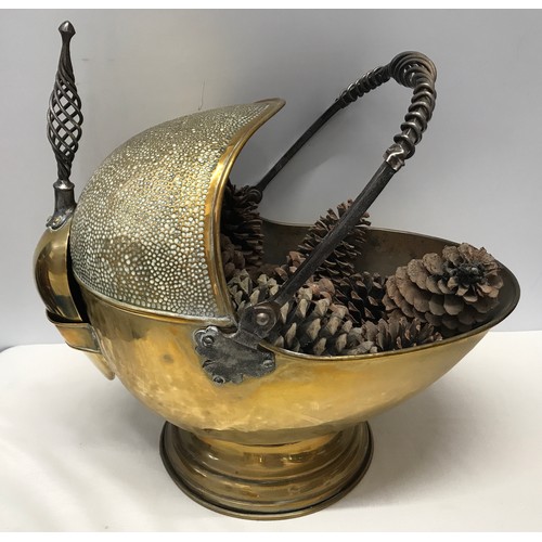 924 - A large brass coal helmet with shovel. Hammered finish with wrought iron handles. Approx. 42cms h x ... 