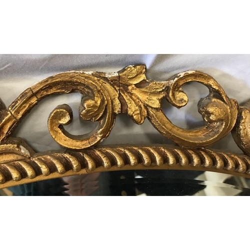 926 - A decorative gilt framed oval bevel edged wall mirror. Frame size 75cms x 47cms.