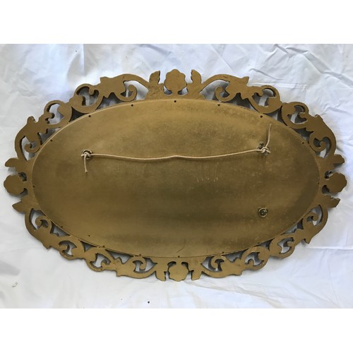 926 - A decorative gilt framed oval bevel edged wall mirror. Frame size 75cms x 47cms.