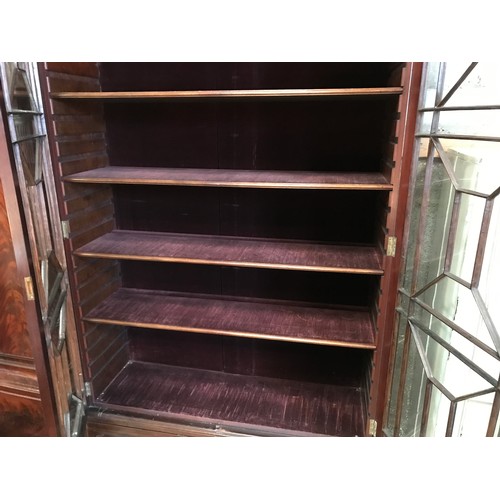 1365 - A two door glazed mahogany display cabinet with two drawers at base and lion head handles. 196cms h ... 