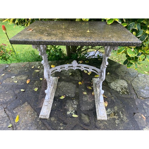 1546 - A cast iron garden table with reconstituted stone top. 76cms w x 51cms d x 73cms h.