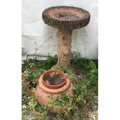 1558 - A reconstituted stone tree trunk bird bath and a terracotta planter. Bird bath 74cms h x 42cms w at ... 