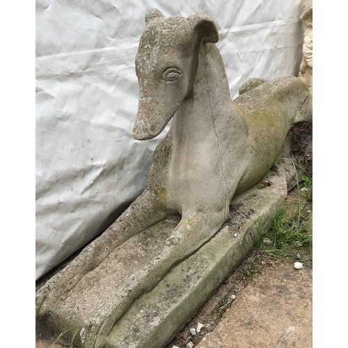 1560 - A large concrete garden ornament of a Grey Hound. 50cms h x 102cms l at base x 28cms w at base