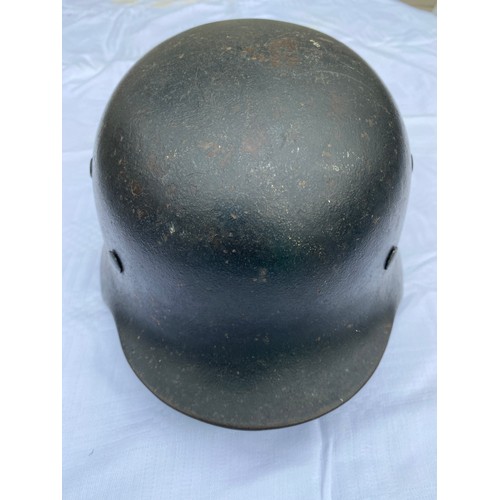 902 - A WWII German helmet with eagle to side and leather liner. Metal interior stamped 4859 and SE64.