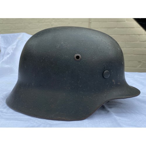 902 - A WWII German helmet with eagle to side and leather liner. Metal interior stamped 4859 and SE64.