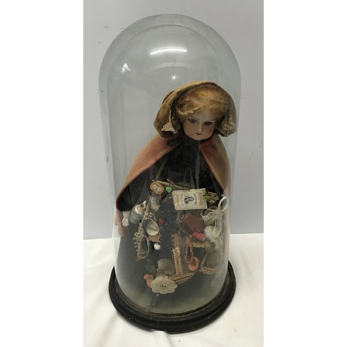 908A - A good example of a Victorian pedlar doll on a circular ebonised base under a glass dome. Doll with ... 