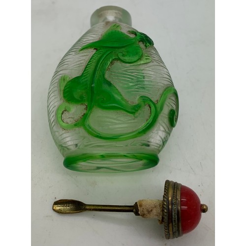 90 - Chinese clear and green glass overlay snuff bottle with dragon decoration. 8cms h.