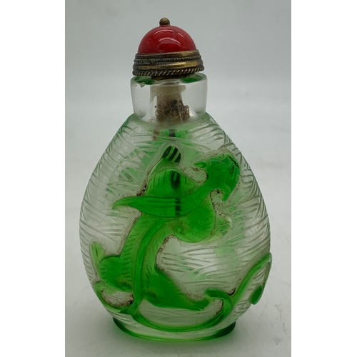 90 - Chinese clear and green glass overlay snuff bottle with dragon decoration. 8cms h.