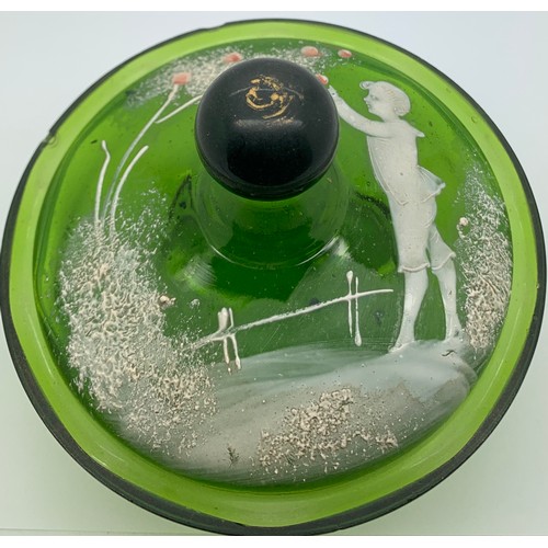 97 - A 19thC green glass lidded jar with Mary Gregory style decoration depicting a boy picking apples.