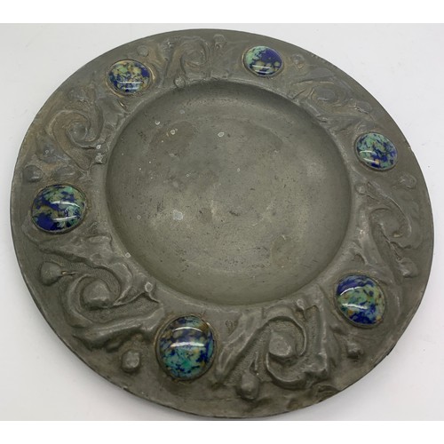 561 - An Arts and Crafts pewter plate with ceramic cabouchons to the border. 15.5cms d.