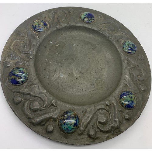 561 - An Arts and Crafts pewter plate with ceramic cabouchons to the border. 15.5cms d.