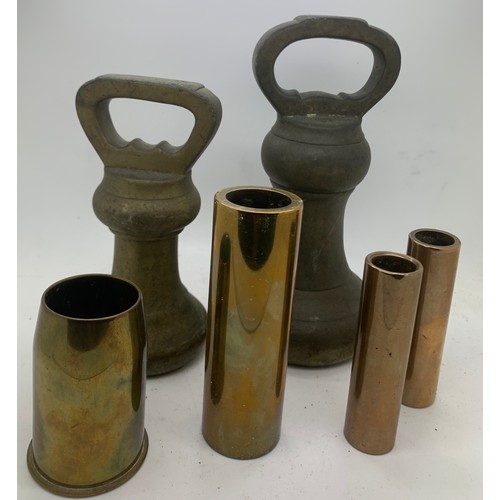 568 - A selection of brass to include 2 bell weights, shell case etc. Bell weights are 3.18 kg and 1.82 kg... 