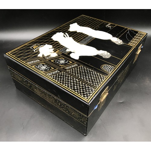 610 - A Japanese black lacquered jewellery box with a mother of pearl lid decorated with Geisha girls and ... 