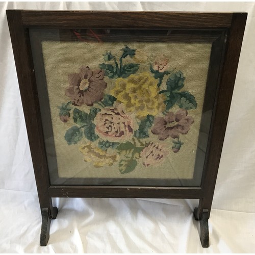 612 - An oak framed firescreen with floral wool work panel. 66cms h x 53cms w.