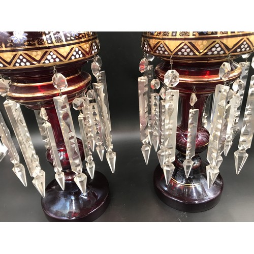 107 - A pair of gilt and floral painted ruby glass lustres with clear glass droplets. 39cms h.