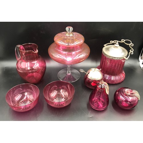 113 - A selection of cranberry glass ware to include a tall lidded pedestal 27cms h, biscuit barrel with s... 