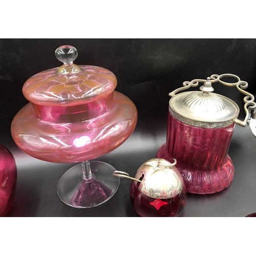 113 - A selection of cranberry glass ware to include a tall lidded pedestal 27cms h, biscuit barrel with s... 