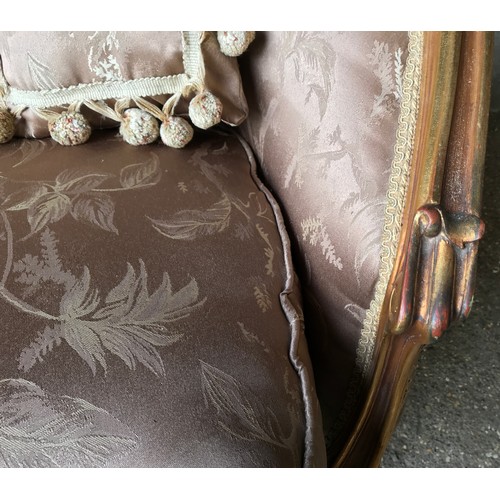 743 - A 19thC carved gilded wooden framed single seat sofa with floral upholstery and a pair of tassel cus... 