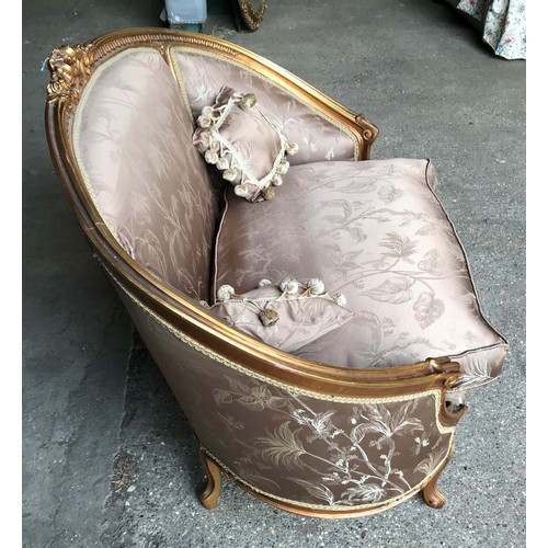 743 - A 19thC carved gilded wooden framed single seat sofa with floral upholstery and a pair of tassel cus... 