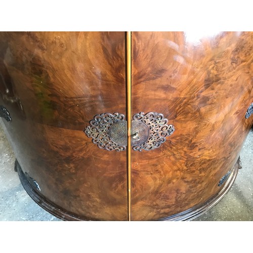 748 - A walnut veneered half round side cabinet with decorative brass fittings, shelved interior and cabri... 