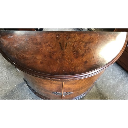 748 - A walnut veneered half round side cabinet with decorative brass fittings, shelved interior and cabri... 