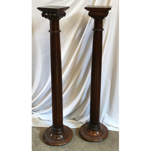 763 - A pair of oak torchere stands with Corinthian columns. 118cms h x 29cms w at base.