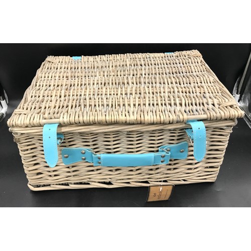 571 - A wicker picnic basket and contents set for four people. 45cms w x 35cms d x 21cms h.