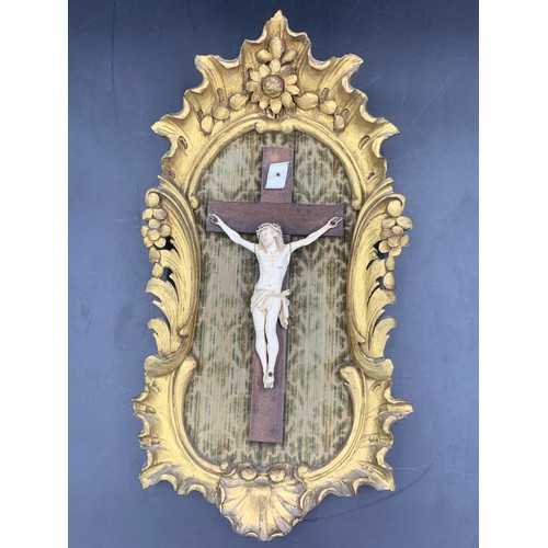 634 - Crucifix in gilt wood frame with fabric backing.