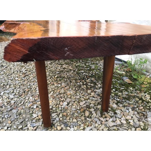 725 - A natural pine coffee table on teak legs. 125cms w x 59cms d x 41cms h.